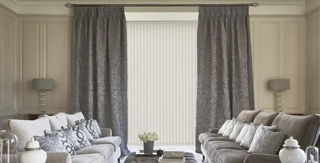 Hang curtains over vertical blinds